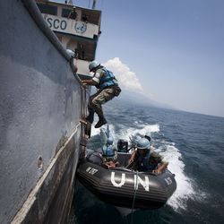 Mitarbeiter der MONUSCO bei einer Trainingseinheit Mitarbeiter der UN mit blauen Helmen steigen von einem Schlauchboot auf ein größeres Schiff um.