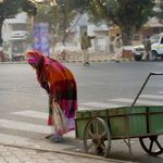 Eine Frau fegt im Bundesstaat Gujarat eine Straße
