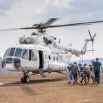 UN Photo/Jorkim Jotham Pituwa Mehrere Personen laufen auf einen rotierenden Hubschrauber zu