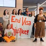 Eine Gruppe junger Leute steht mit einem Transparent, auf dem "End Visa Injustice" steht.