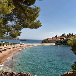 Ein wunderschöne Bucht, kleiner Strand, wenige Häuser und Bäume und türkisblaues Meer